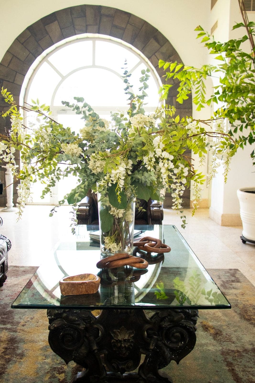 Lobby with stone arch and floral arrangement on an antique table