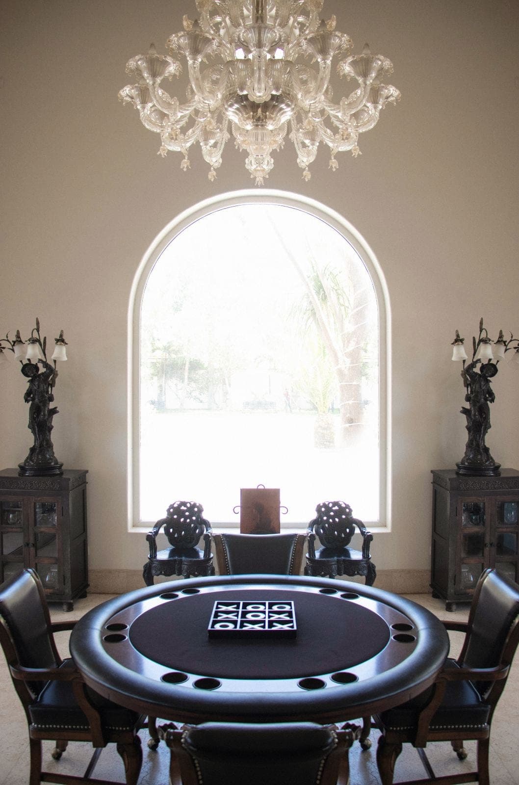 Games salon with crystal chandelier and arched window
