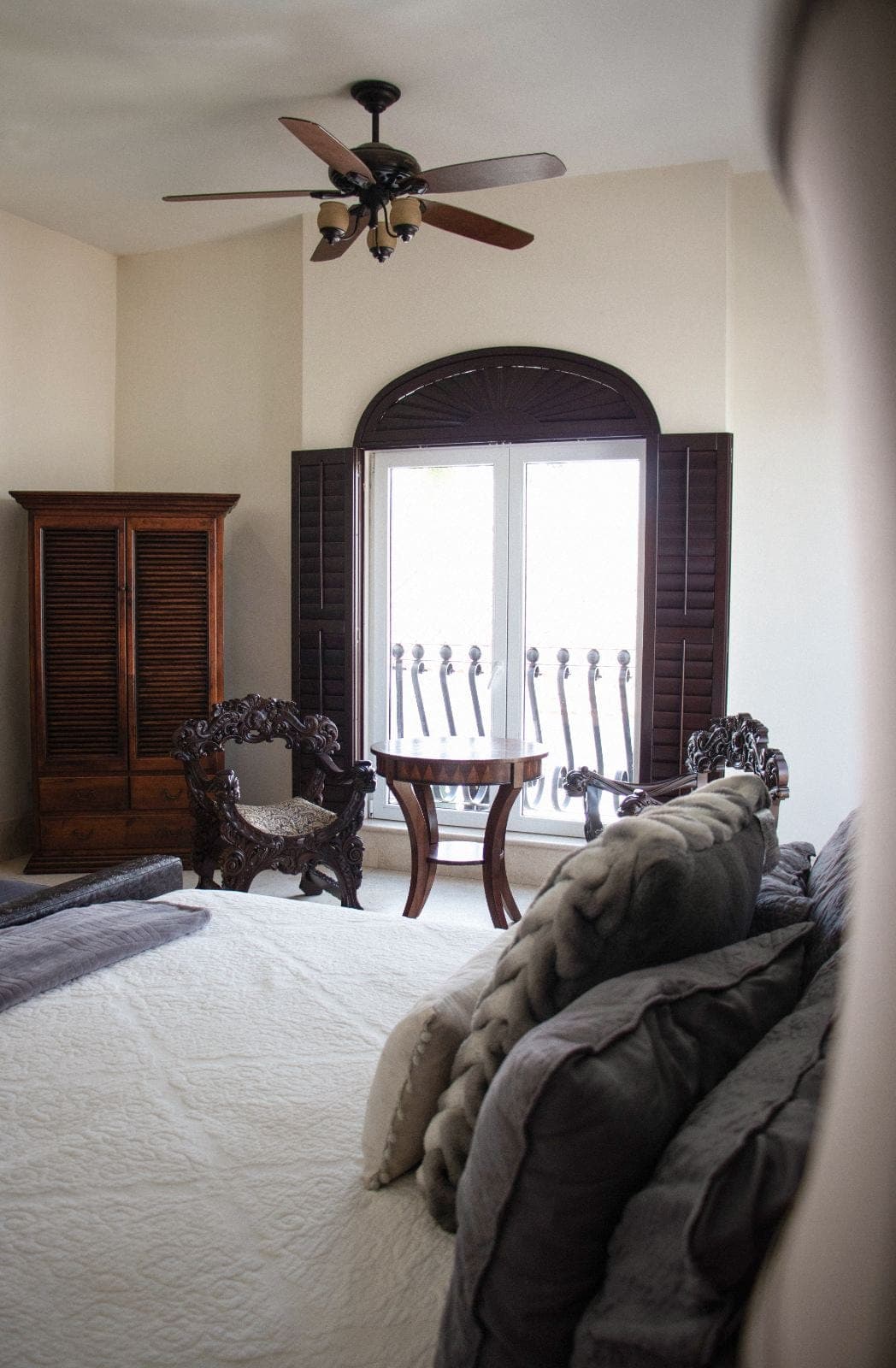 Habitación Owen: cama con edredón bordado, sillones tallados y balcón