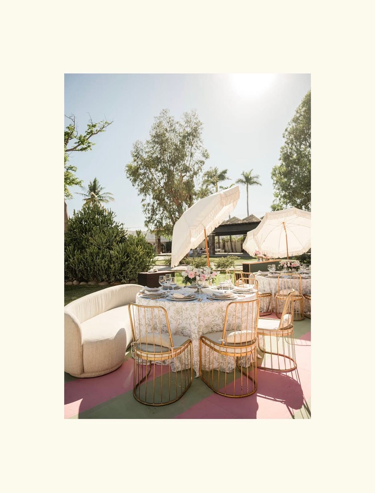 Pista a rayas con sillas doradas y sala lounge para un evento en el jardín