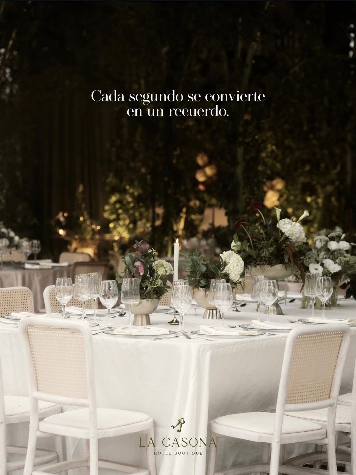 Banquete nocturno con velas, cristalería y sillas de bejuco