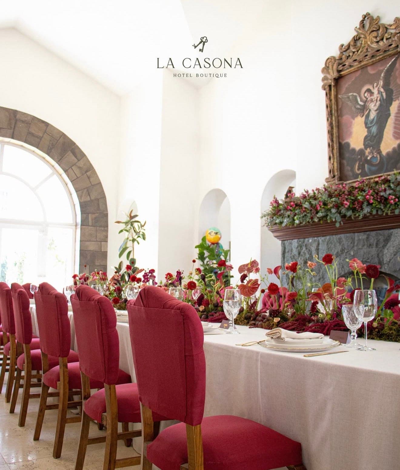 Mesa imperial con sillas vino y jardinera de flores en el salón