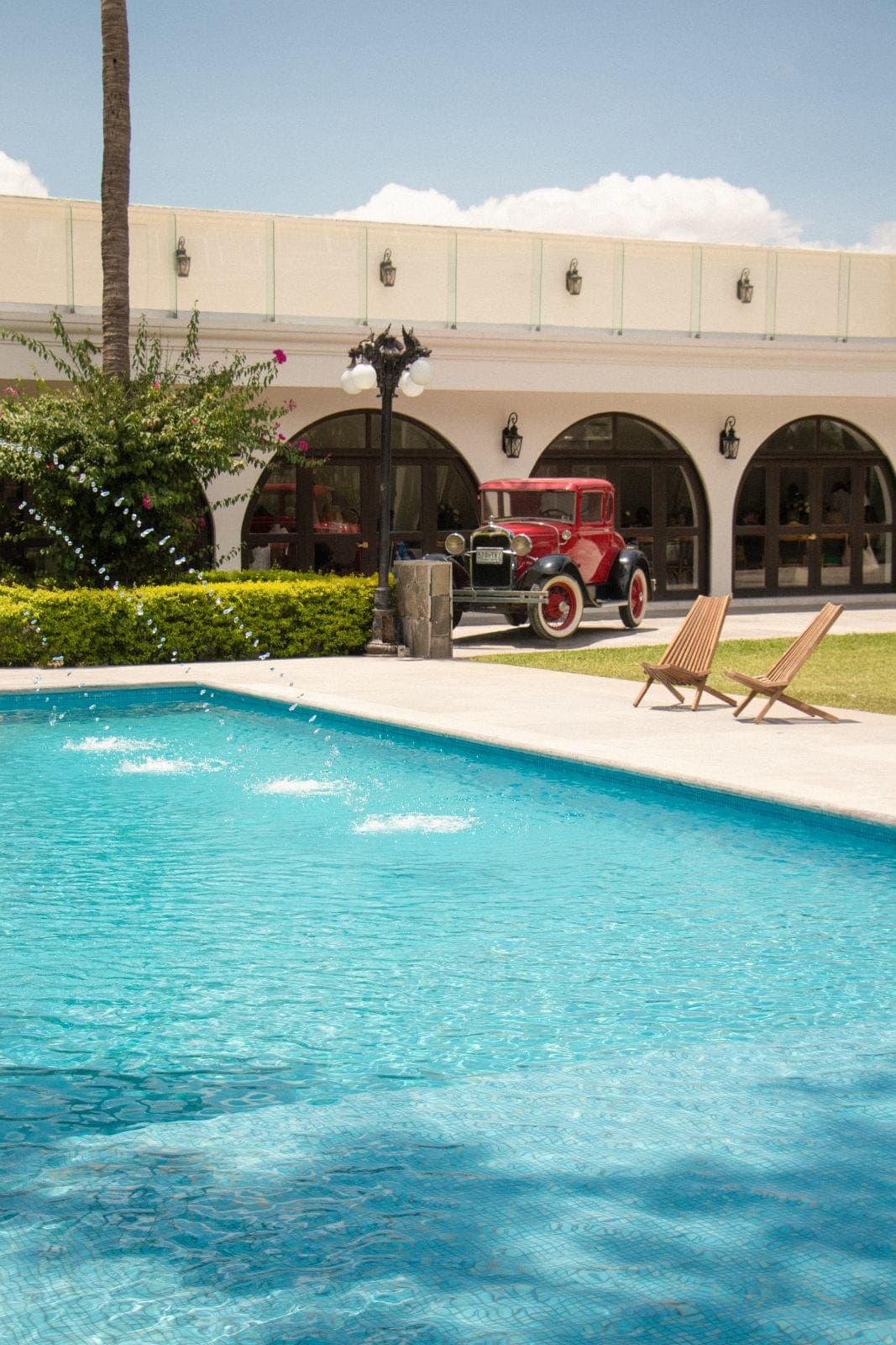 Fountain pool beside the arches and La Casona’s classic car